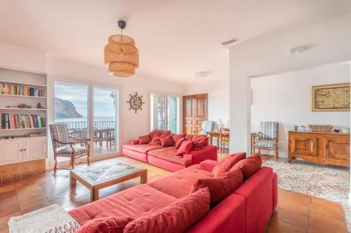 a living room with a red couch and a table at Le Panorama de Cassis - Welkeys in Cassis