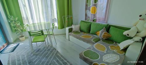 a living room with a green couch and a teddy bear at Къща Поморини Несебър in Nesebar