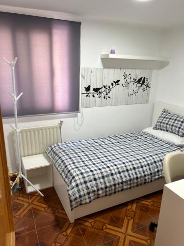 a small bedroom with a bed and a window at Habitación privada en piso compartido Madrid in Madrid