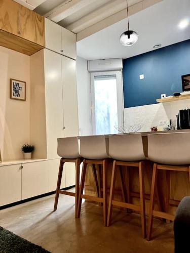 une cuisine avec un bar et des tabourets. dans l'établissement Le Madeleine, 2pers wifi et Tv, à Nantes