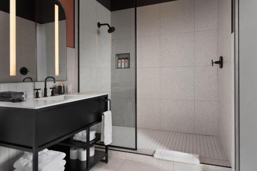 W łazience znajduje się umywalka i prysznic. w obiekcie Kinn Guesthouse Downtown w mieście Milwaukee