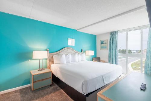 a hotel room with a bed and a blue wall at Bay Club Resort in Ocean City