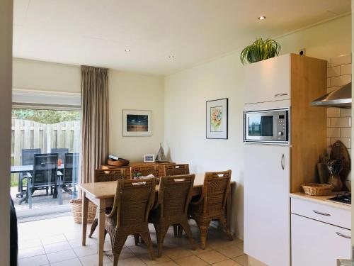 a kitchen and dining room with a table and chairs at Vrij uitzicht Texel in De Koog