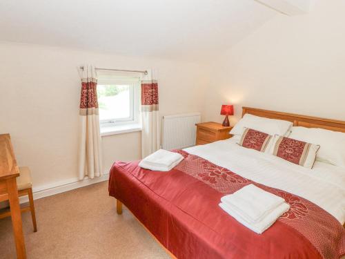 sypialnia z dużym łóżkiem i oknem w obiekcie Goswick Hall w mieście Bowland Bridge