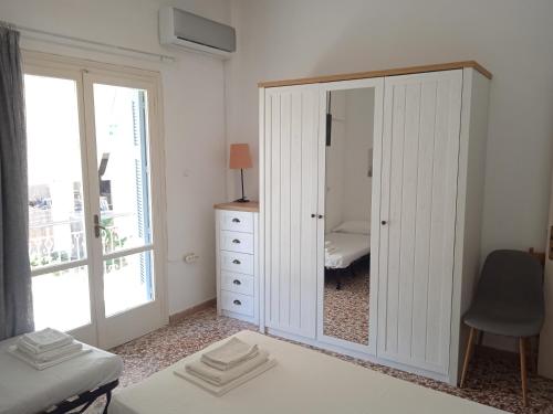 a bedroom with a dresser and a large mirror at Elinas Room in Poros
