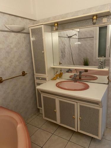 une salle de bain avec un lavabo, un miroir et une baignoire dans l'établissement Maison dans village calme, à Arles