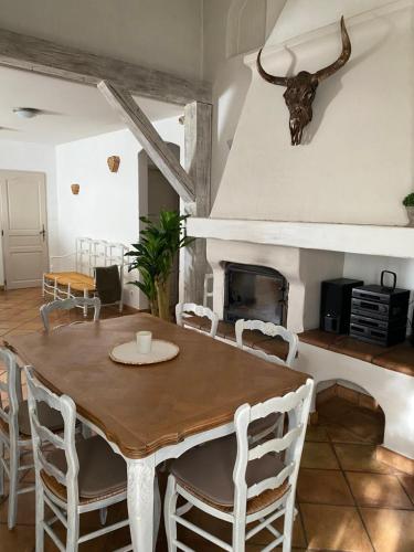 une salle à manger avec une table et des chaises et une cheminée dans l'établissement Maison dans village calme, à Arles