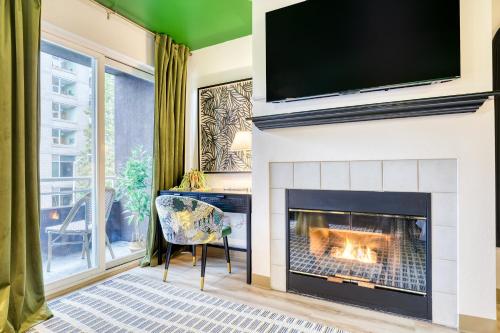 a living room with a fireplace with a tv above it at Quest Travels in Seattle