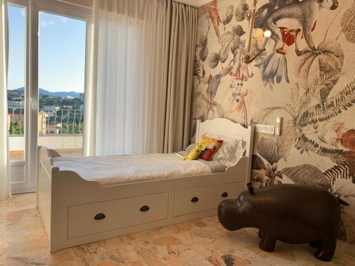 une chambre avec un lit avec une grande fenêtre dans l'établissement Villa Brise des Pins, au Cannet