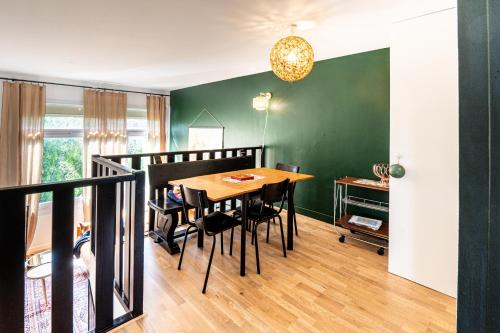 een eetkamer met een tafel en een groene muur bij The Good Vibes Honfleur & pkg included in Honfleur