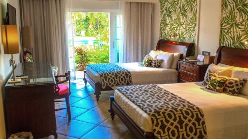 a hotel room with two beds and a window at Coco Palm in Gros Islet