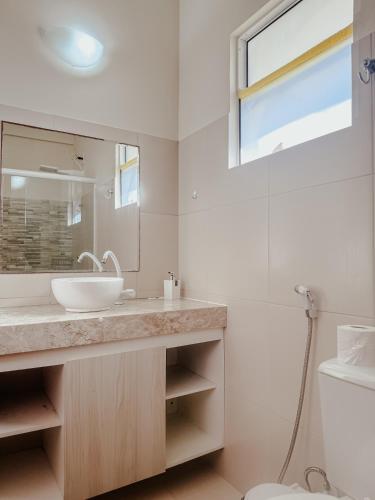 a bathroom with a sink and a mirror at Kitecabana Apartamento in Caucaia