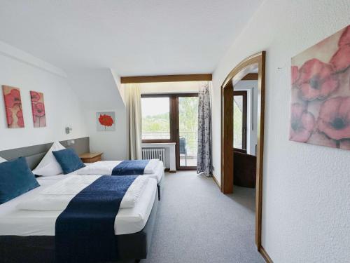 Garni Hotel Moselschild في أورزيغ: غرفة فندقية بسريرين ومرآة