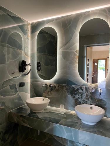 two sinks in a bathroom with two mirrors at Villa Diamond in Parga