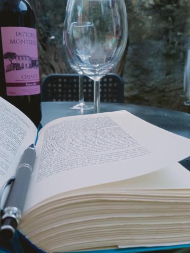 an open book on a table with a wine glass at Small Heaven in Florentine hills in Florence
