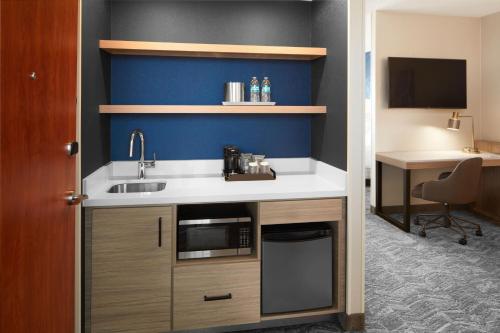 a kitchen with a sink and a desk in a room at SpringHill Suites by Marriott Virginia Beach Oceanfront in Virginia Beach