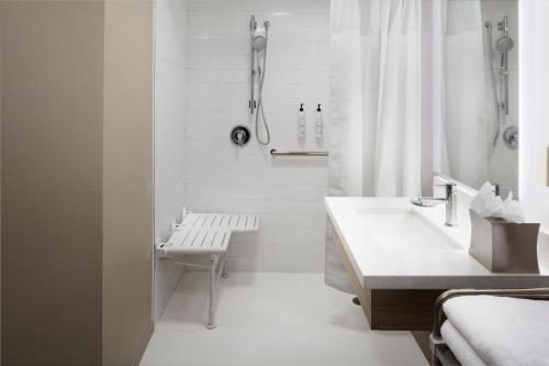 a white bathroom with a sink and a shower at SpringHill Suites by Marriott Virginia Beach Oceanfront in Virginia Beach