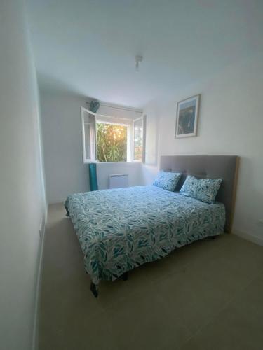 une chambre avec un lit et une fenêtre dans l'établissement Joli appart proche de la mer, à Marseille