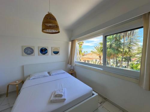 a bedroom with a bed and a large window at Real Center in Larnaka