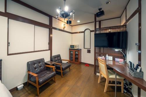 a room with two chairs and a desk and a television at Grand Hotel Narita Airport - Vacation STAY 56496v in Narita