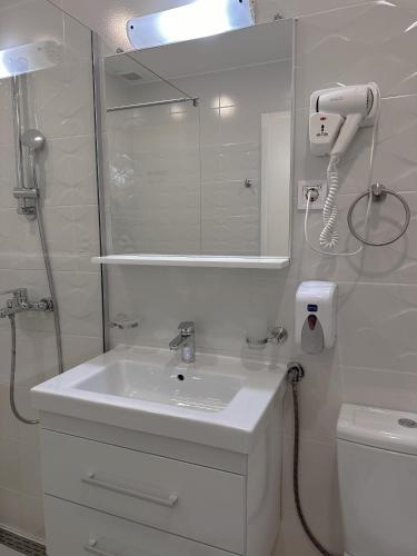 a white bathroom with a sink and a shower at Golden Sunset Apartments in Ohrid
