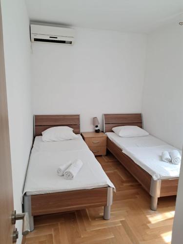 two twin beds in a room with wooden floors at Belveder Montenegro in Rafailovici