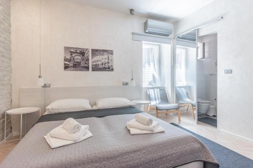a bedroom with a large bed with two white towels at OLD TOWN PULA STUDIO APARTMENTS in Pula