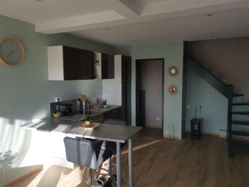 - une cuisine avec une table et un escalier dans une chambre dans l'établissement Gîte tout confort avec baignoire balneo', à Boos