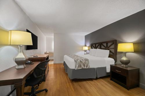 オーランドにあるAmericas Best Value Inn Orlando, FLのベッドと机と机があるホテルの部屋