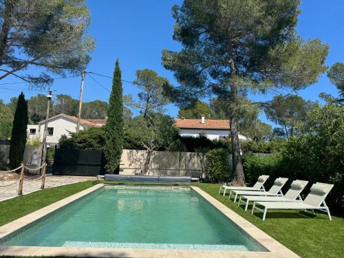 - une piscine dans une cour avec des chaises longues blanches dans l'établissement Sea and Sun, à Saint-Raphaël