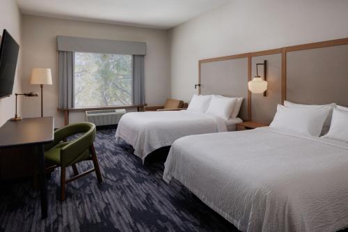 a hotel room with two beds and a desk and a window at Fairfield Inn & Suites by Marriott Kelowna in Kelowna