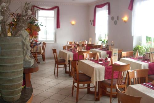 a dining room with white tables and chairs and windows at Komforthotel-Restaurant Württemberger Hof in Bad Saulgau