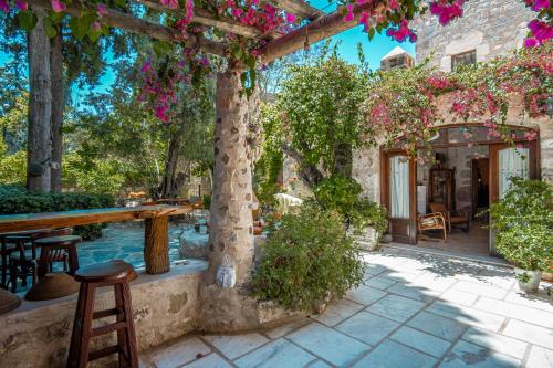a patio with a table and chairs and flowers at Ha La Bodrum in Bodrum City