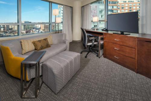 a living room with a couch and a desk with a television at Courtyard Washington, DC/U.S. Capitol in Washington