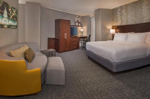 ワシントンにあるコートヤード ワシントン DC / U.S. キャピトルのベッド、ソファ、椅子が備わるホテルルームです。