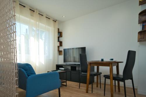 un salon avec une table et une télévision dans l'établissement Studio climatisé refait à neuf, à Villeneuve-Loubet