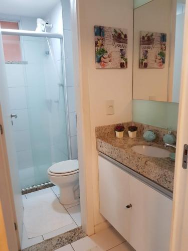 uma casa de banho com um WC, um lavatório e um chuveiro em PALM BEACH Porto das Dunas, apartamento todo climatizado TÉRREO a 350 metros Beach Park em Aquiraz