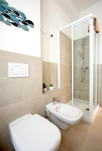 a bathroom with a toilet and a shower and a sink at Appartamenti 2 in Dervio