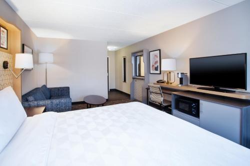 a hotel room with a bed and a flat screen tv at Holiday Inn Canton-Belden Village by IHG in Canton