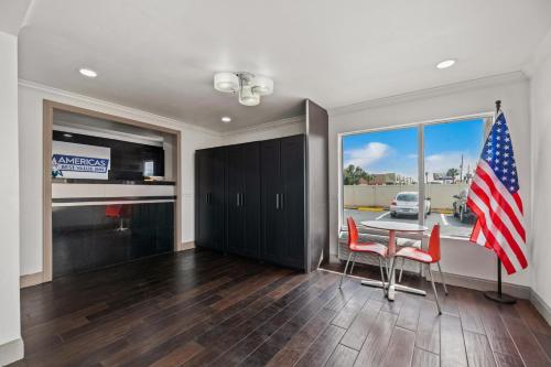 a kitchen with a table with chairs and an american flag at Americas Best Value Inn Orlando, FL in Orlando