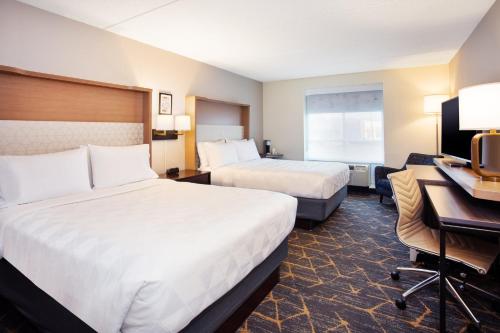 a hotel room with two beds and a desk at Holiday Inn Canton-Belden Village by IHG in Canton