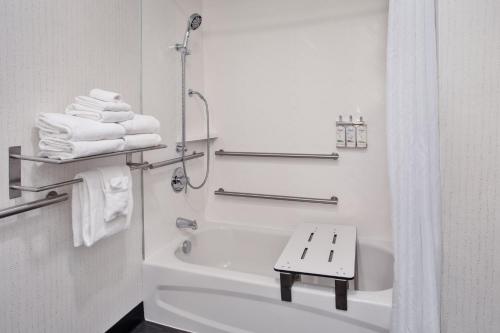 a white bathroom with a tub and a sink and towels at Holiday Inn Canton-Belden Village, an IHG Hotel in Canton