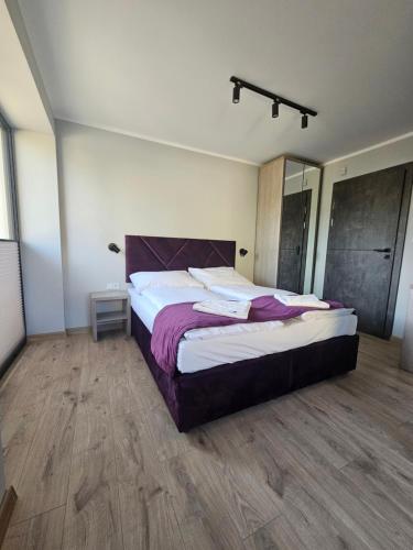 a bedroom with a large bed and a wooden floor at Dom wakacyjny Welle Dziwnów in Dziwnów