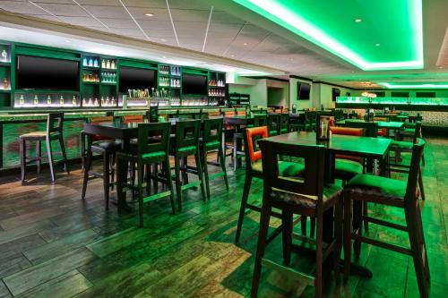 a bar with tables and chairs in a restaurant at Holiday Inn Canton-Belden Village by IHG in Canton