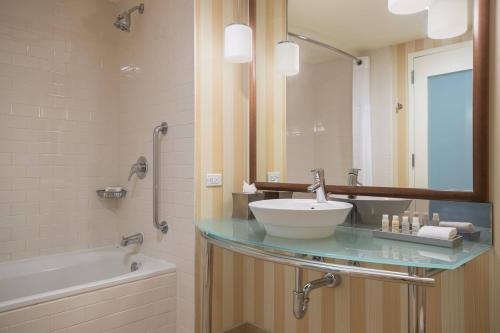 uma casa de banho com um lavatório, uma banheira e um espelho. em Renaissance ClubSport Aliso Viejo Laguna Beach Hotel em Aliso Viejo