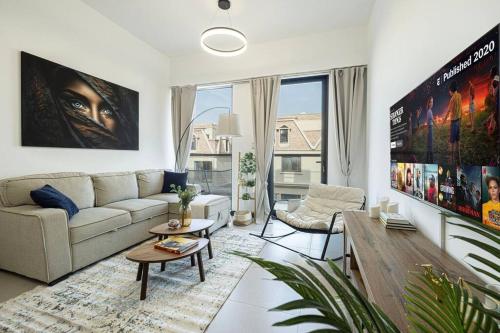 a living room with a couch and a table at Large 1BR in JVC Sleeps 4 Rooftop, Pool & Gym in Dubai