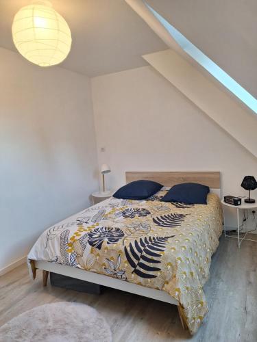 een slaapkamer met een bed met een kleurrijke deken bij Le Vaugerin in Bléré