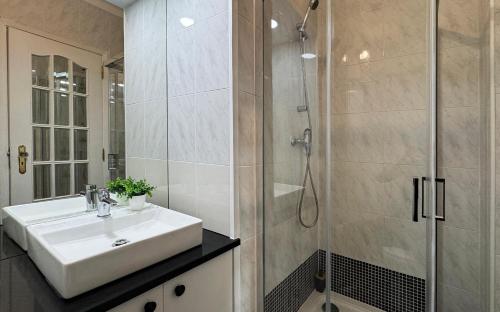 a bathroom with a sink and a shower at Sunny 4 Bedroom Apartment - with View in Coimbra