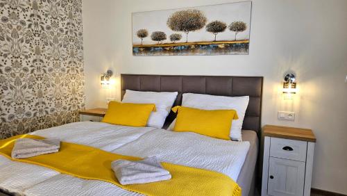 Un dormitorio con una cama con dos almohadas amarillas. en Apartmány Podzámčí, en Lednice