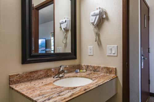La salle de bains est pourvue d'un lavabo avec miroir et d'un téléphone. dans l'établissement Coachman Inn, à Bellingham